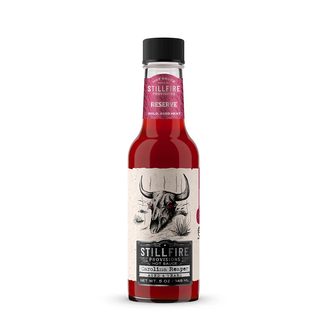 Bottle of Stillfire Provisions Carolina Reaper hot sauce on a white background