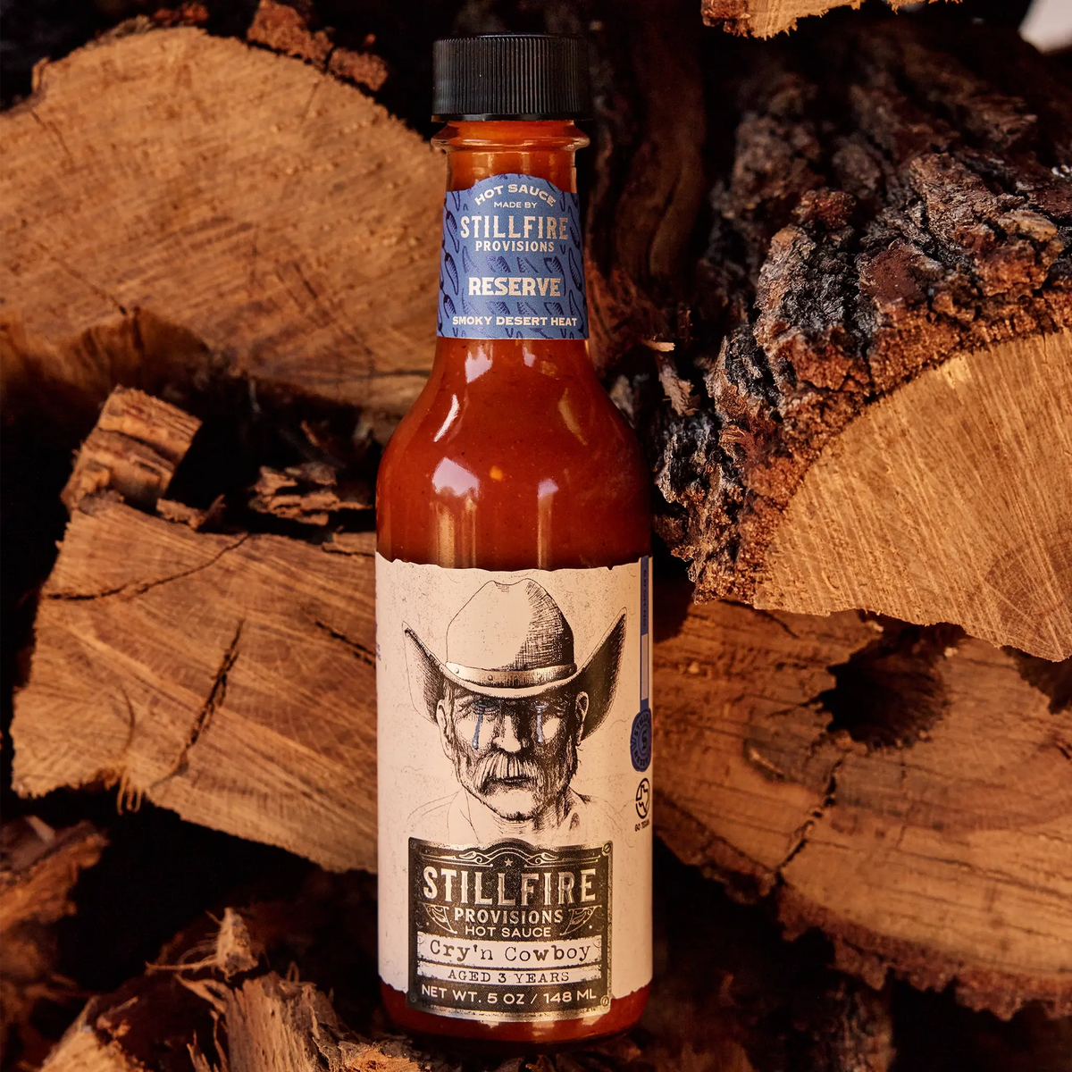 Cry'n Cowboy Hot Sauce on fire wood backdrop