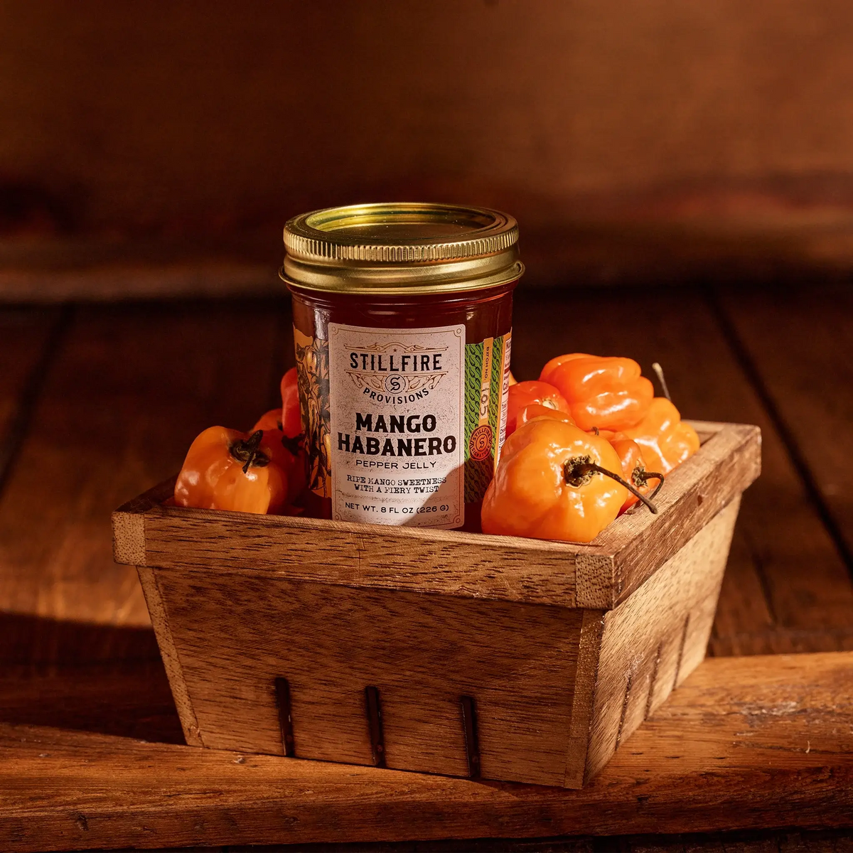 Mango Habanero Pepper Jelly in pepper basket on a wood table.