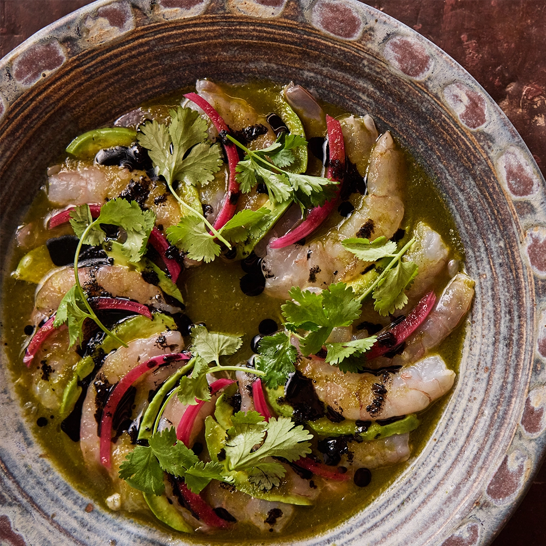 Garnished dish with shrimp and vegetables on a decorative ceramic plate