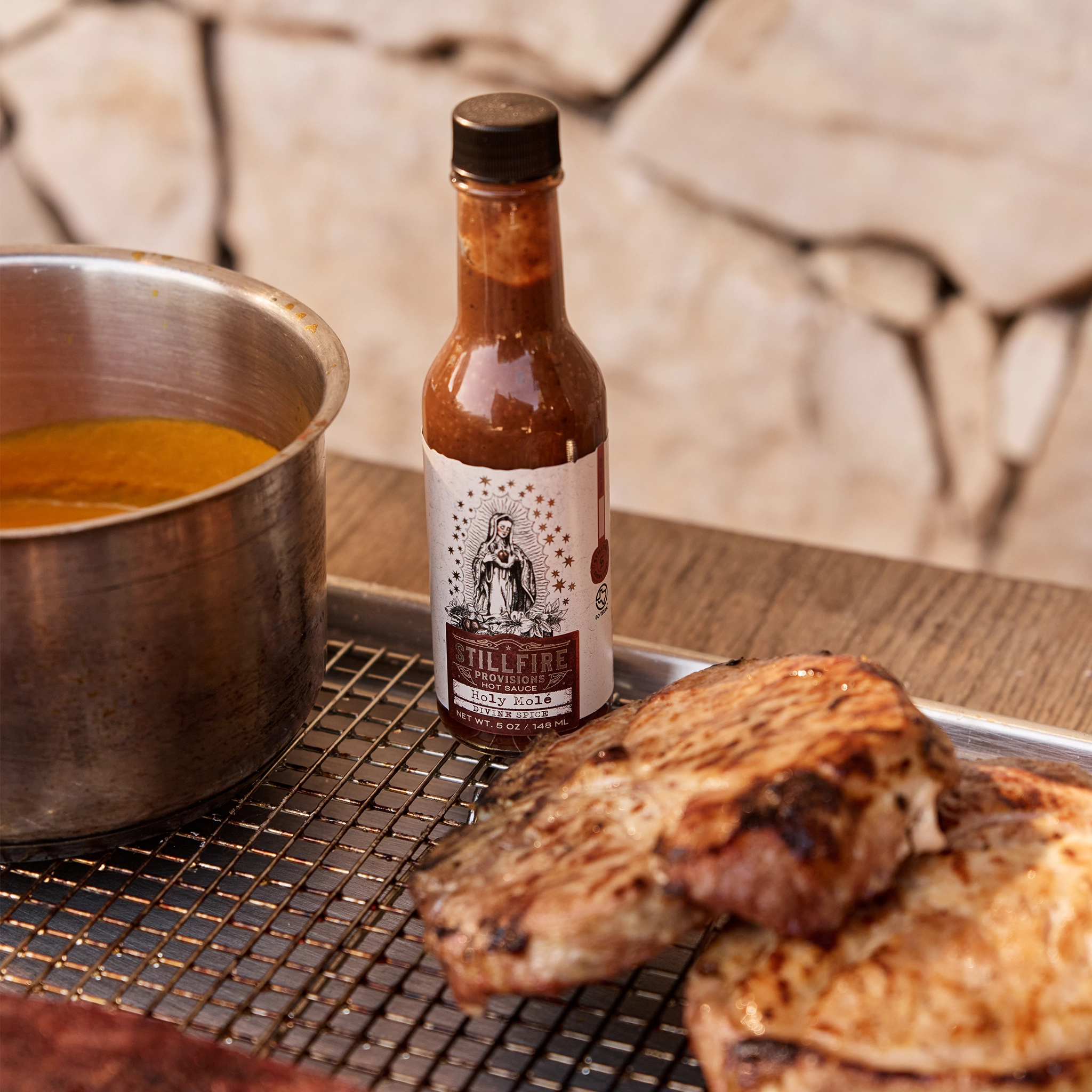 Holy Mole Hot Sauce next to grilled pork chops
