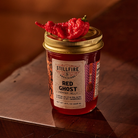 Red Ghost Pepper Jelly with a Red Ghost Pepper on top of the jar.