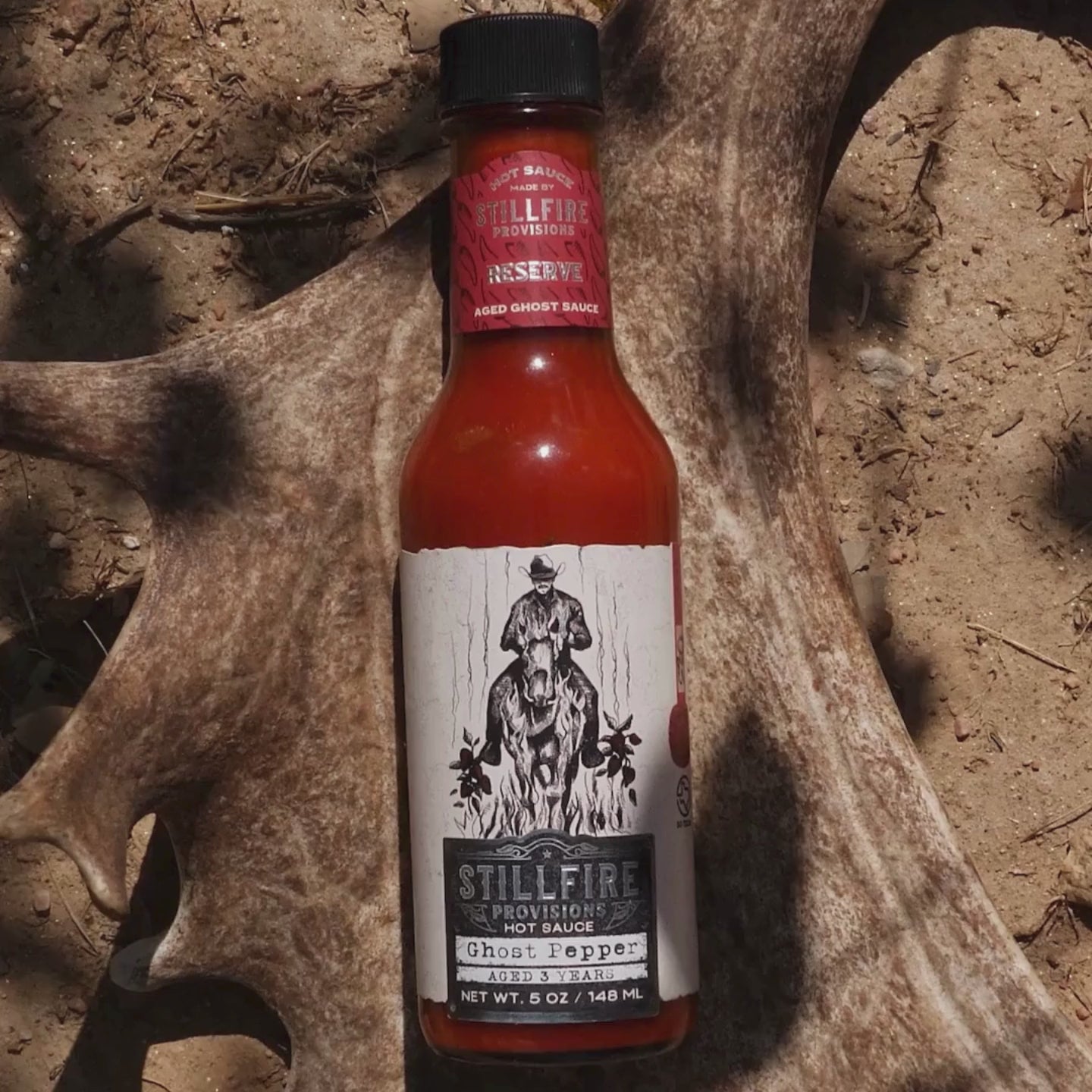 Carolina Reaper Hot Sauce by Stillfire Provisions in an antler on the Texas ground 